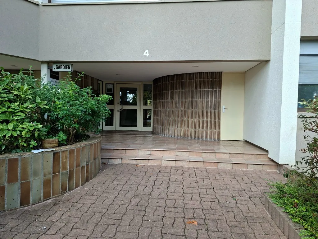 L’entrée du bâtiment 4, reconnaissable à son numéro « 4 » et au panneau « Gardien ».